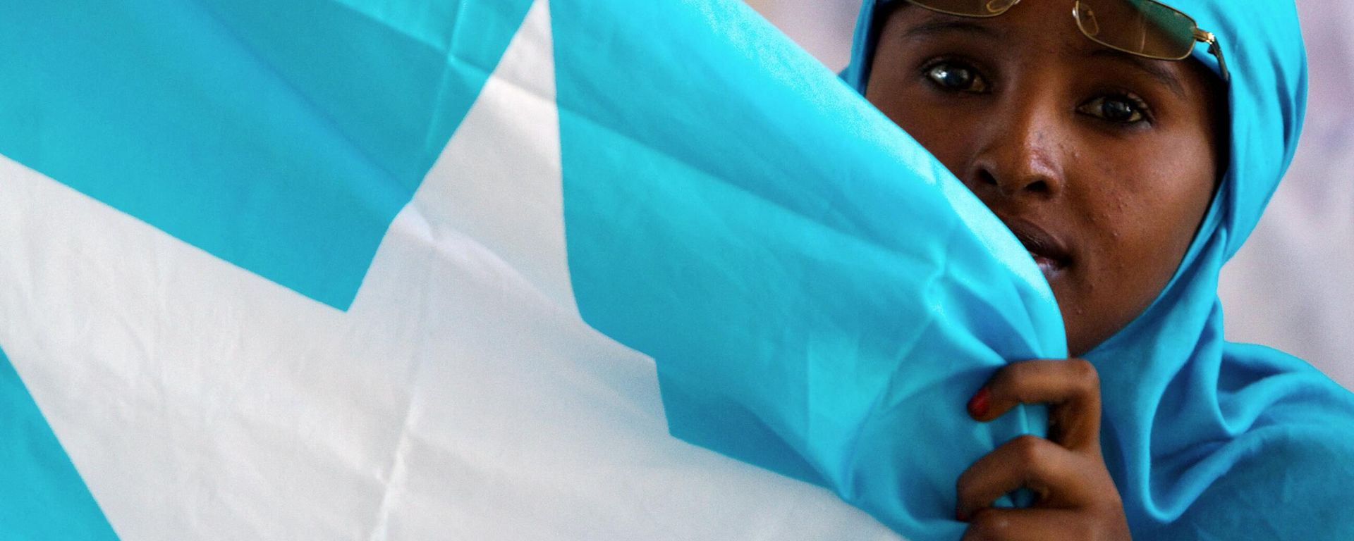 A Somali woman holds the national flag during a ceremony marking President Sheikh Sharif Sheikh Ahem's first year in office at the Villa Somalia presidential palace in Mogadishu on January 29, 2010 A Somali woman holds the national flag during a ceremony marking President Sheikh Sharif Sheikh Ahem's first year in office at the Villa Somalia presidential palace in Mogadishu on January 29, 2010 - Sputnik International, 1920, 25.01.2023