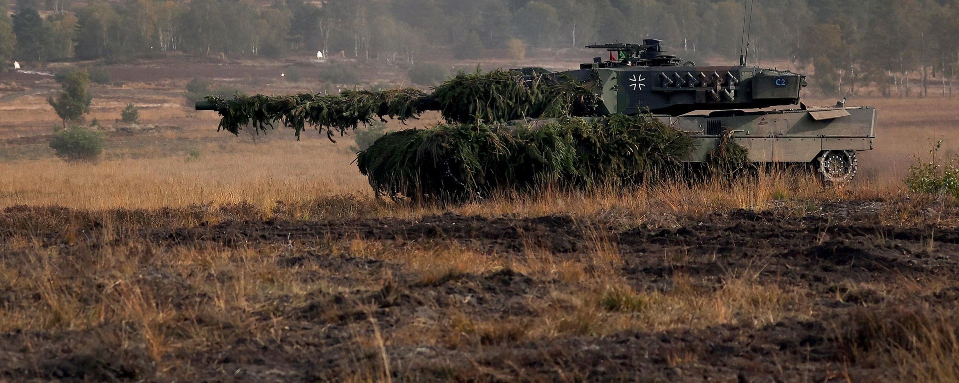 A Leopard 2 battle tanks of the German armed forces Bundeswehr drives during a visit by the German Chancellor to the German Bundeswehr's troops during a training exercise at the military ground in Ostenholz, northern Germany, on October 17, 2022 A Leopard 2 battle tanks of the German armed forces Bundeswehr drives during a visit by the German Chancellor to the German Bundeswehr's troops during a training exercise at the military ground in Ostenholz, northern Germany, on October 17, 2022 - Sputnik International, 1920, 26.01.2023
