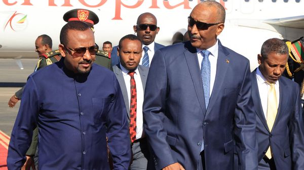 Ethiopian Prime Minister Abiy Ahmed (l) walks alongside Sudanese Army Chief Abdel Fattah al-Burhan (C) at Khartoum Airport during a welcome ceremony on January 26, 2023.  - Sputnik International