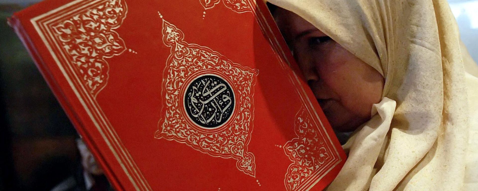 A Lebanese woman displaced from a border village in the south of the country holds a copy of the Quran at a hotel in the port city of Tyre, July 22, 2006. A Lebanese woman displaced from a border village in the south of the country holds a copy of the Quran at a hotel in the port city of Tyre, July 22, 2006. - Sputnik International, 1920, 27.01.2023