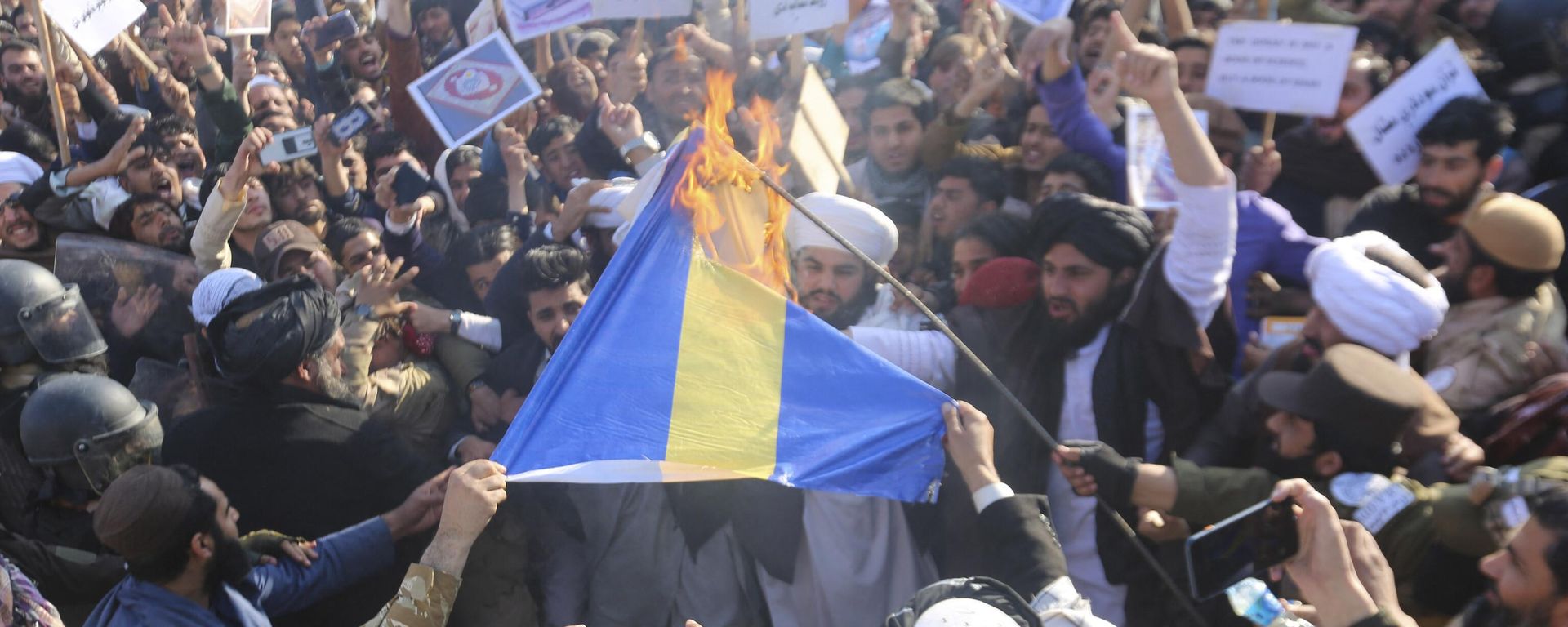 Afghans shout slogans as they burn a flag of Sweden during a protest against the burning of the Koran by Swedish-Danish far-right politician Rasmus Paludan, after Friday prayers in Jalalabad on January 27, 2023. Afghans shout slogans as they burn a flag of Sweden during a protest against the burning of the Koran by Swedish-Danish far-right politician Rasmus Paludan, after Friday prayers in Jalalabad on January 27, 2023. - Sputnik International, 1920, 27.01.2023