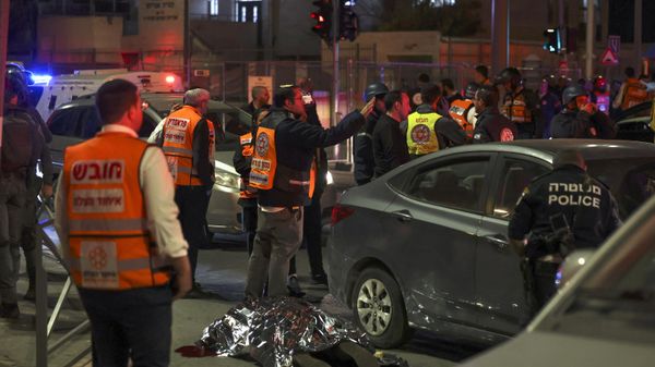 Israeli emergency service personnel and security forces stand near a covered body at the site of a reported attack in a settler neighbourhood of Israeli-annexed east Jerusalem, on January 27, 2023. - Sputnik International