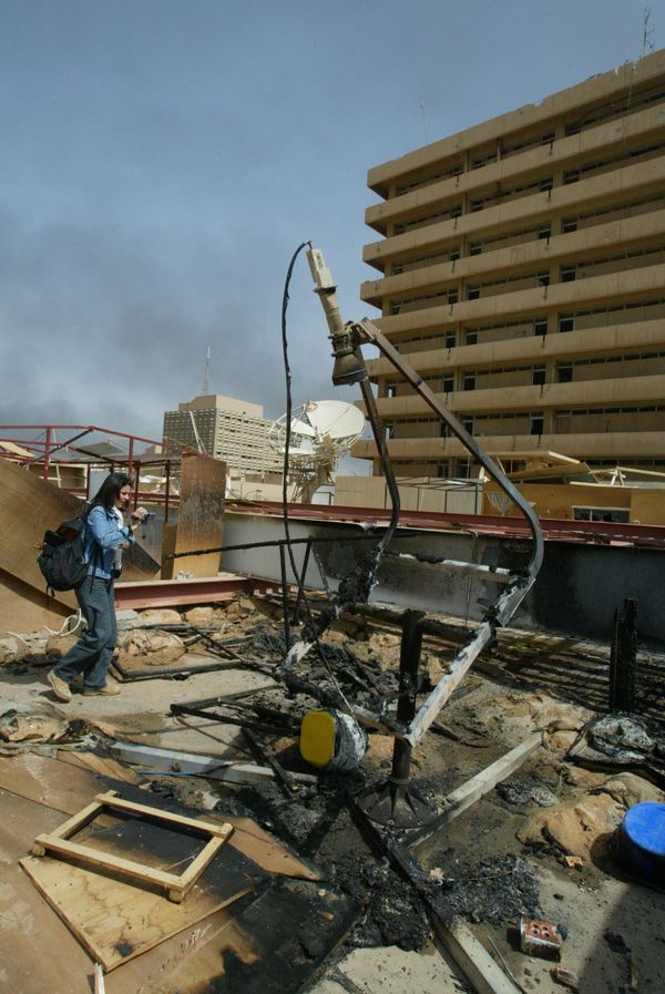 Greek reporter Elefteria Pentaraki films the destruction of "tent city" on the roof of Baghdad's press center March 31, 2003, after it was hit by a coalition missile overnight.  AFP PHOTO/Patrick BAZ (Photo by PATRICK BAZ / AFP) - Sputnik International