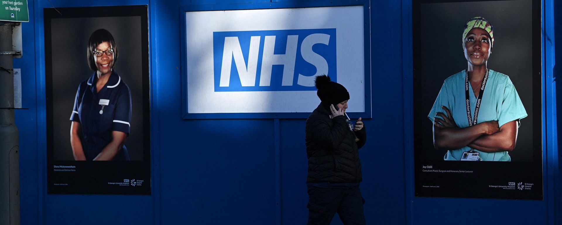 Pedestrians walk past images of workers of Britain's National Health Service, south London, January 5, 2022 - Sputnik International, 1920, 03.02.2023