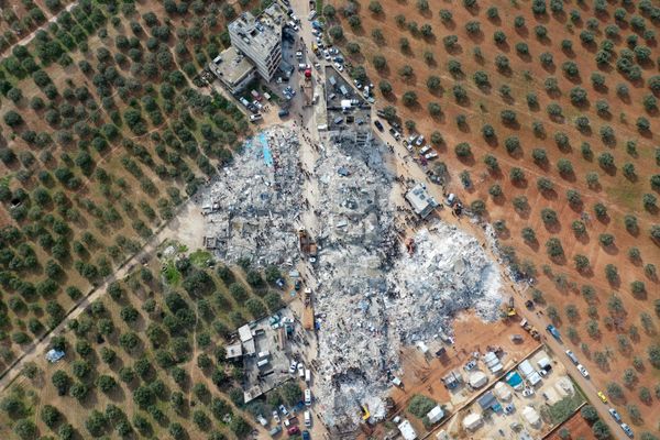 An aerial view showing residents searching for victims and survivors amidst the rubble of collapsed buildings after an earthquake in the town of Besnia near the town of Harim, in Syria's rebel-held north-western Idlib province on the border with Turkey on 6 February 2023. - Sputnik International