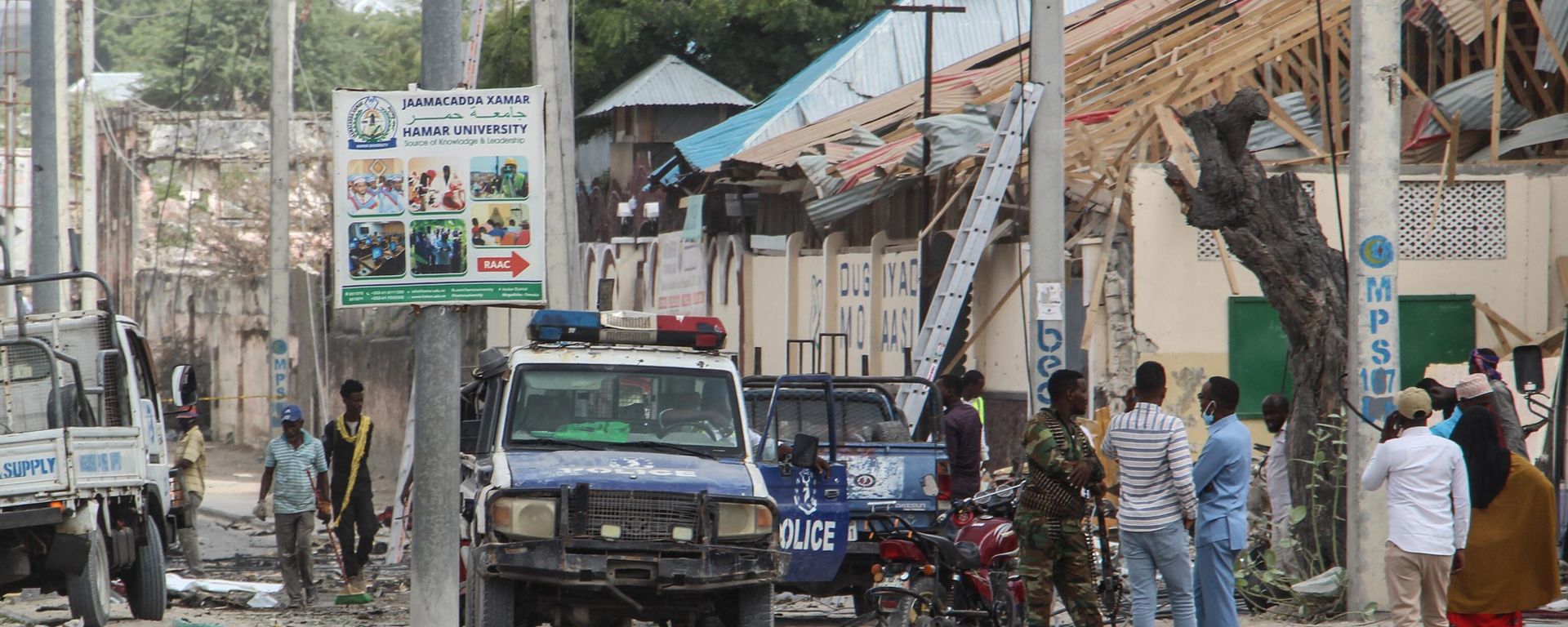 Police officers and people stand at the bomb explosion site in Mogadishu, Somalia, on November 25, 2021. Police officers and people stand at the bomb explosion site in Mogadishu, Somalia, on November 25, 2021. - Sputnik International, 1920, 07.02.2023