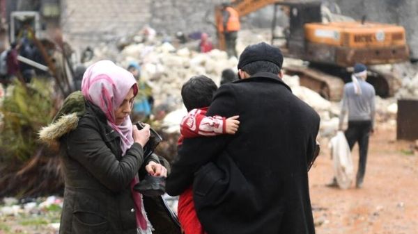People watch as construction equipment clears debris while the search continues for survivors - Sputnik International