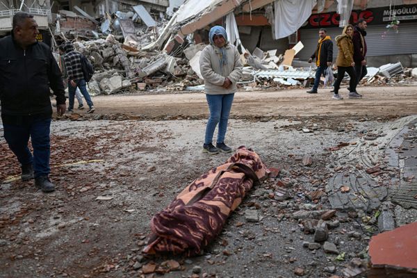 A woman weeps as she stands beside the body of a victim in Hatay on 7 February 2023, a day after a 7.8-magnitude earthquake struck the country's south-east. - Sputnik International