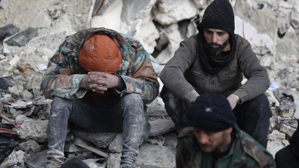 People react as they sit on the wreckage of collapsed buildings, in Aleppo, Syria, Tuesday, February 7, 2023.  - Sputnik International