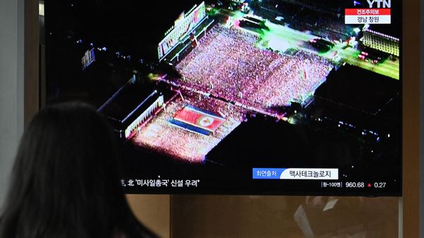 A woman watches a television screen showing a news broadcast with a satellite image of a military parade held in Pyongyang to mark the 75th founding anniversary of its armed forces, at a railway station in Seoul on February 9, 2023 - Sputnik International