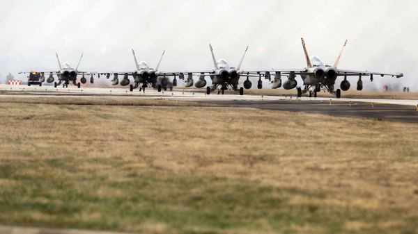 F-18 growler jet fighters seen through a fence are parked at the Nato airbase in Aviano, Italy on Saturday 19 March 2011. At this point, NATO's top decision-making body was meeting to review military plans for a no-fly zone over Libya. - Sputnik International