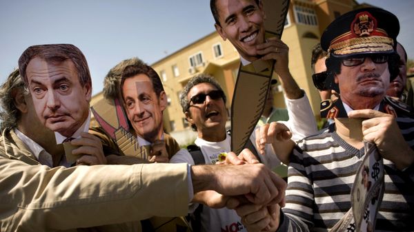 Protesters wearing masks featuring (L-R) Spanish Prime Minister Jose Luis Rodriguez Zapatero, French President Nicolas Sarkozy, US President Barack Obama, Libyan leader Moamer Kadhafi take part in an anti-war demonstration calling on  governments to stop bombing Libya in front of the Base Naval de Rota, on March 26, 2011, in Rota near Cadiz. - Sputnik International