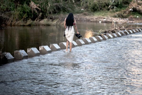 A woman crosses a collapsed bridge on the Muzindi river after the floods which severely affected Nkomazi municipality, in Mpumalanga, on February 15, 2023. - Sputnik International