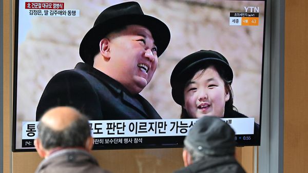 People watch a television screen showing a news broadcast with an image of North Korean leader Kim Jong Un (L) and his daughter presumed to be named Ju Ae (R) attending a military parade held in Pyongyang to mark the 75th founding anniversary of its armed forces, at a railway station in Seoul on February 9, 2023 - Sputnik International
