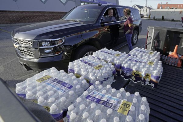 Becky Rance, center, talks with a police officer as she hands out water from the back of her truck in downtown East Palestine, Ohio, as the cleanup of portions of a Norfolk Southern freight train continues. (AP Photo/Gene J. Puskar) - Sputnik International