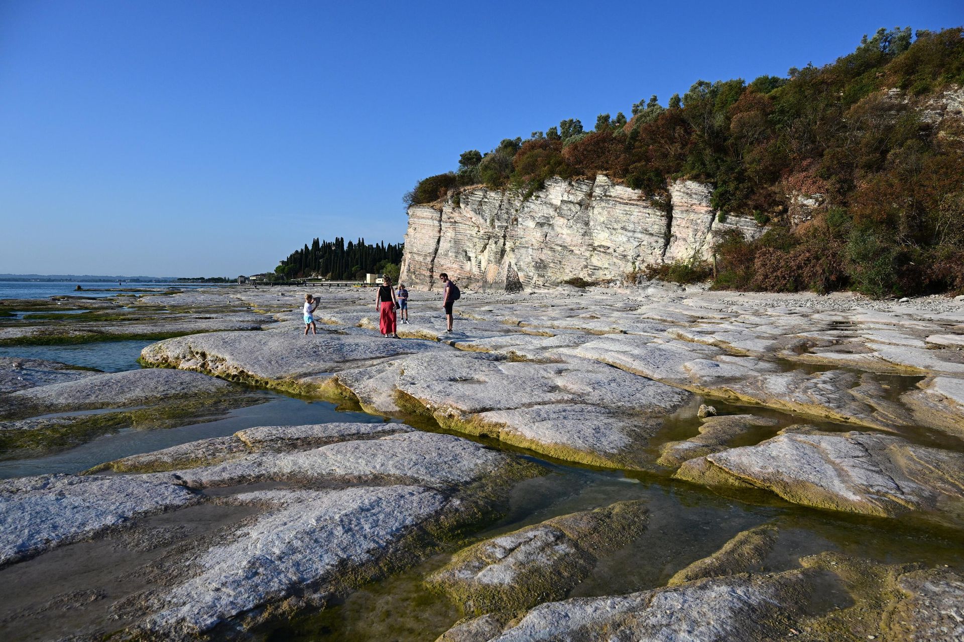 People walk on August 16, 2022 on the rocks of the peninsula of Sirmione on Lake Garda, northern Italy, as the lake's waters recede due to severe drought. People walk on August 16, 2022 on the rocks of the peninsula of Sirmione on Lake Garda, northern Italy, as the lake's waters recede due to severe drought. - Sputnik International, 1920, 22.02.2023