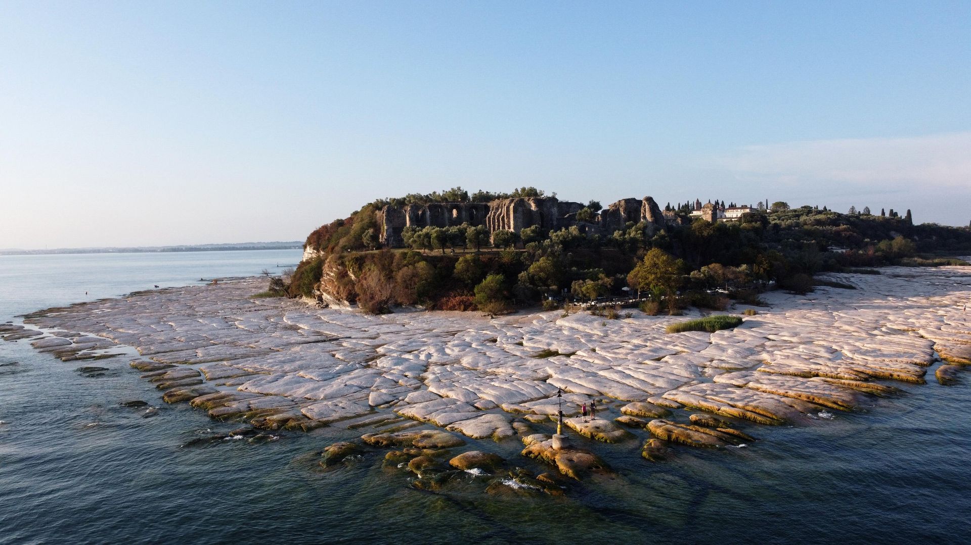 An aerial view taken on August 16, 2022 shows the peninsula of Sirmione on Lake Garda, northern Italy, as the lake's waters recede due to severe drought. An aerial view taken on August 16, 2022 shows the peninsula of Sirmione on Lake Garda, northern Italy, as the lake's waters recede due to severe drought. - Sputnik International, 1920, 22.02.2023