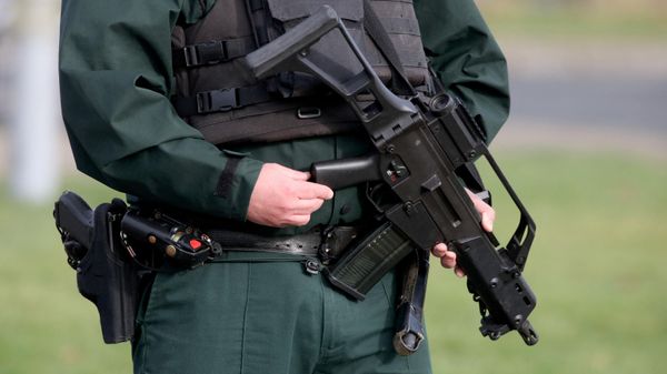 An armed police officer stands guard at the scene of a shooting of an off duty policeman  at the Killyclogher Road sports complex in the northern Irish town of Omagh - Sputnik International