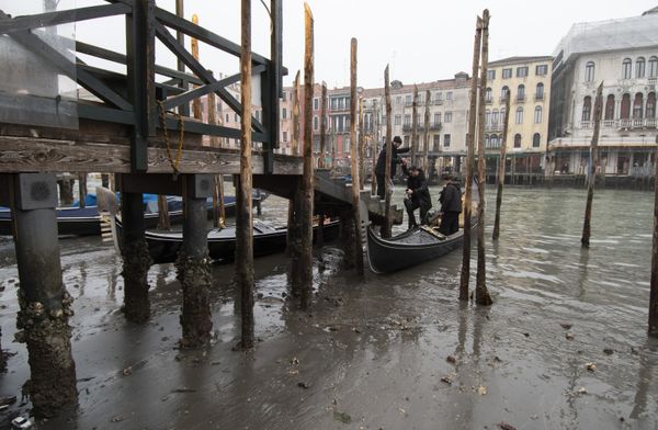 Passengers get off a gondola docked along a canal during a low tide in Venice, Italy. Some of Venice's secondary canals have practically dried up lately due a prolonged spell of low tides linked to a lingering high-pressure weather system.  - Sputnik International