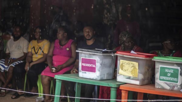 People sit in line next to the ballot boxes displayed on the tables, as they wait to cast their votes at a polling station during the presidential elections in Agulu, Nigeria, Saturday, Feb. 25, 2023.  - Sputnik International