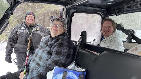 This Feb. 26, 2023 photo courtesy of the Maine Warden Service, Maine Game Warden Brad Richard is shown with Angela Bussell and Kimberly Pushard.  The two women were missing for several days and were found more than 150 miles from home in a rural part of the state. (Jonathan Parker/Maine Warden Service via AP) - Sputnik International