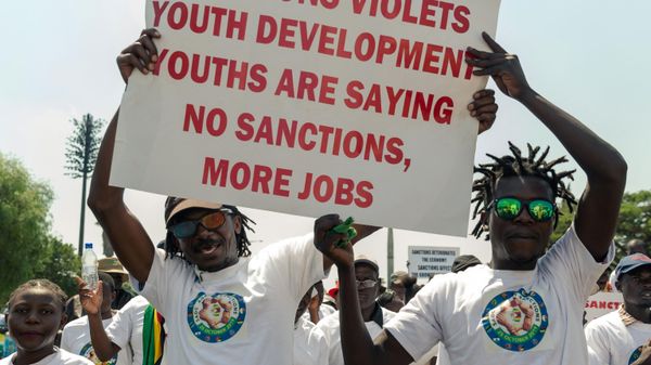 Demonstrators hold a placard during a rally to denounce US and EU economic sanctions against Zimbabwe at the National Stadium, in the capital Harare, October 25, 2019 - Sputnik International