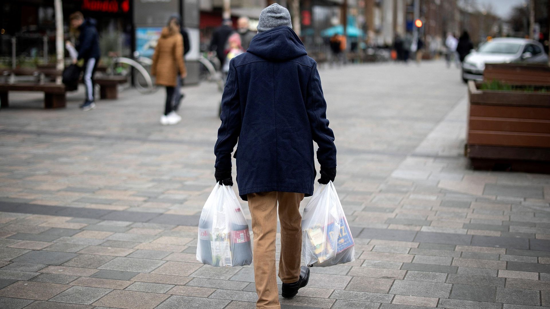 A shopper carries his purchases in east London on February 13, 2022 as UK annual inflation struck 5.4 percent in December. - Sputnik International, 1920, 21.03.2023