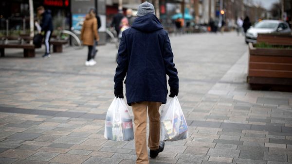 A shopper carries his purchases in east London on February 13, 2022 as UK annual inflation struck 5.4 percent in December. - Sputnik International