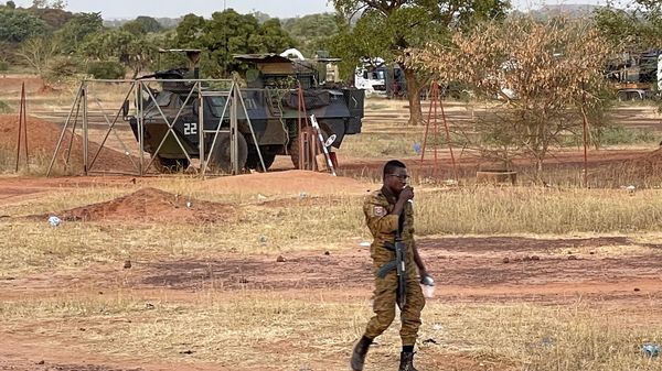 A Burkinabe soldier walks past a French armored personnel carrier as part of a French military convoy heading to Niger, stopped by protesters in Kaya, Burkina Faso, Saturday Nov. 20, 2021. - Sputnik International
