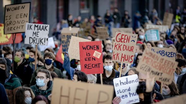 A person holds a placard reading living is a right during a protest to demand Dutch government to intervene in the housing market and take measures for more affordable housing in Utrecht on November 21, 2021.  - Sputnik International