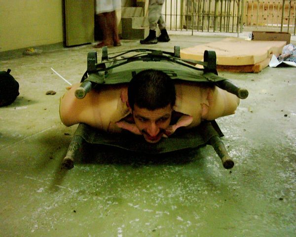 In this picture, an Iraqi prisoner of war is wrapped in foam padding and sandwiched between two stretchers. Usually US soldiers would sit on top of such a "sandwich" making it hard for the prisoner to breath. - Sputnik International