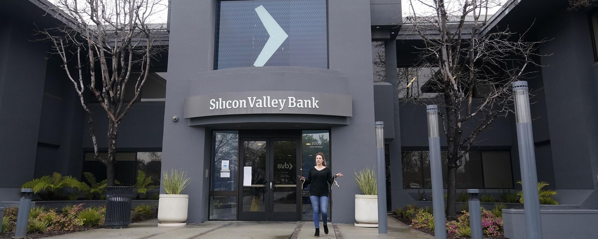 A property managment representative gestures while asking reporters to clear the entrance area to Silicon Valley Bank in Santa Clara, Calif. - Sputnik International, 1920, 13.03.2023