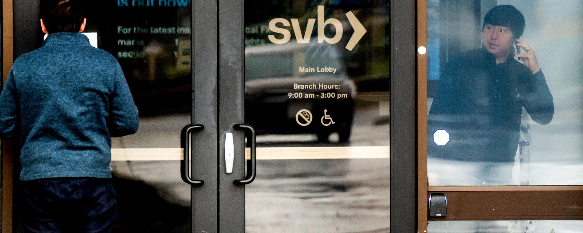 In this file photo taken on March 10, 2023, a customer (L) reads a notice about Silicon Valley Bank’s closure at the bank’s headquarters in Santa Clara, California - Sputnik International, 1920, 14.03.2023