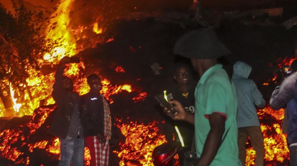 People stand and take selfies in front of lava from the eruption of Mount Nyiragongo, in Buhene, on the outskirts of Goma, Congo in the early hours of Sunday, May 23, 2021.  - Sputnik International