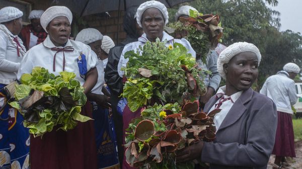 Mourners carry wreathes during a mass funeral procession for mudslide victims at Chilobwe township’s Naotcha Primary school camp in Blantyre, Malawi, on March 15, 2023 - Sputnik International