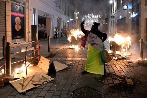 A protester gestures next to burning waste bins during a demonstration in Marseille, in the south of France on 16 March 2023. - Sputnik International