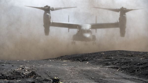 A member of the Japanese Self-Defense Force Amphibious Rapid Deployment Brigade holds position while a US Marine Corps MV-22 Osprey tilt-rotor aircraft takes off during a joint exercise with US Marine Corps personnel at the Higashifuji training area in Gotemba, Shizuoka Prefecture on March 15, 2022.  - Sputnik International