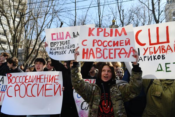 Participants of the "Crimea with Russia Forever" rally stand with placards outside the US Embassy in Moscow.   - Sputnik International