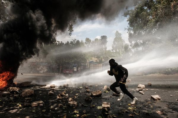 A protester runs away from water released by a police’s water cannon vehicle during a mass rally called by the opposition leader Raila Odinga who claims the last Kenyan presidential election was stolen from him and blames the government for the hike of living costs in Kibera, Nairobi on March 20, 2023. - Sputnik International