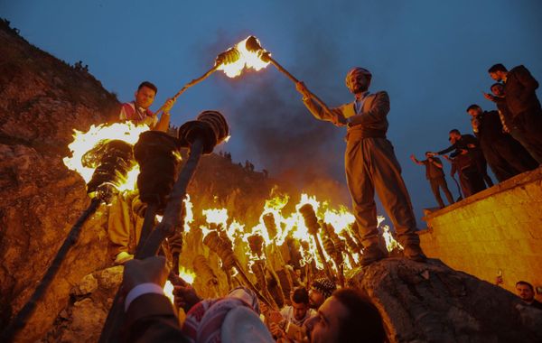 Iraqi Kurds holding lit torches walk up a mountain during celebrations of Nowruz. - Sputnik International