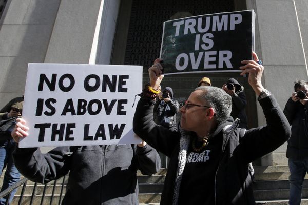 Anti-Trump demonstrators hold placards outside the Manhattan District Attorney's office in New York City.  - Sputnik International