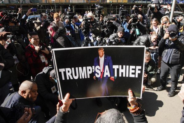A woman holds up a poster as part of a protest in front of the courthouse ahead of former President Donald Trump's anticipated indictment.  - Sputnik International
