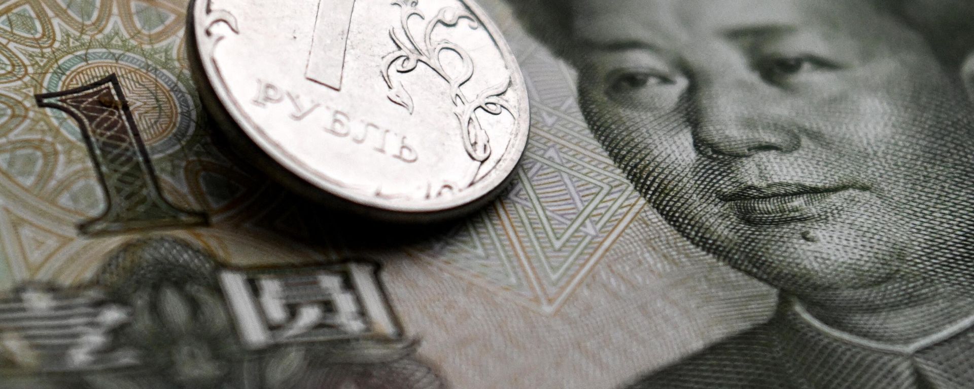 This photograph taken on February 9, 2023 shows a Russian ruble coin and a Chinese yuan banknote in Moscow - Sputnik International, 1920, 23.03.2023