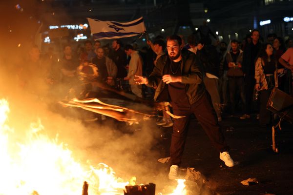 Protesters block a road and hold national flags as they gather around a bonfire during a rally against the Israeli government's judicial reform in Tel Aviv, Israel. - Sputnik International