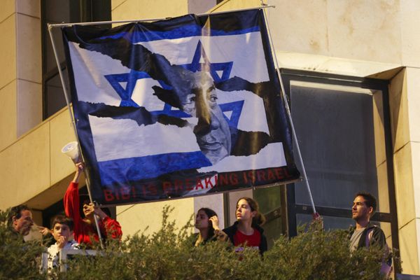 Israeli protesters lift a banner depicting Prime Minister Benjamin Netanyahu during a rally against the government's controversial judicial overhaul bill in Tel Aviv. - Sputnik International