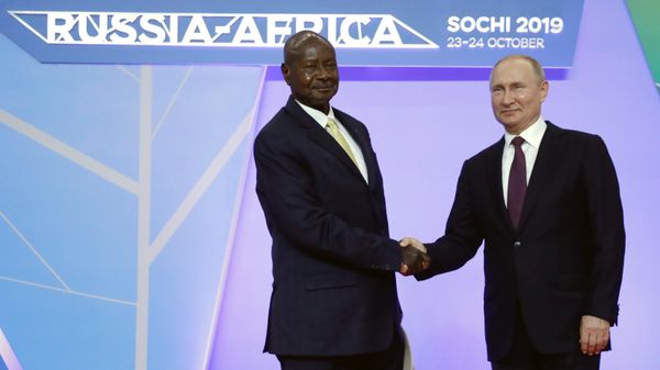 Russian President Vladimir Putin, left, shakes hands with Ugandan President Yoweri Museveni during their meeting on the sideline of Russia-Africa summit in the Black Sea resort of Sochi, Russia, Wednesday, Oct. 23, 2019.  - Sputnik International