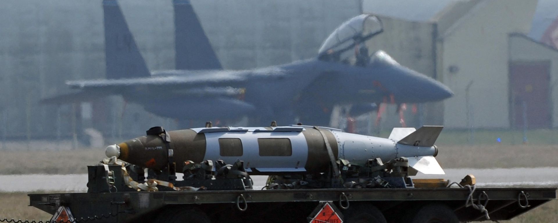 Weapons are carried in front of US airforce F15 jet fighter at the Aviano air base on March 25, 2011. - Sputnik International, 1920, 06.04.2023