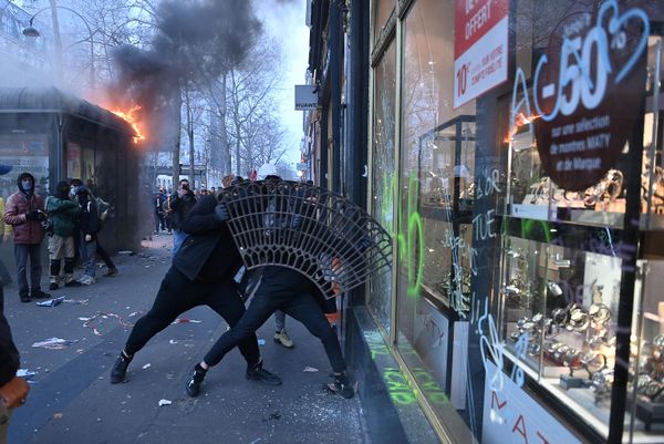 Protesters use a sidewalk tree grid to break the window of a shop on the sidelines of a demonstration as part of a national day of strikes and protests.  - Sputnik International