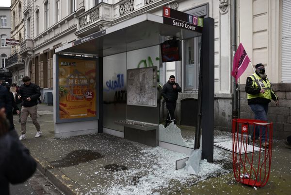 Protesters walk past a damaged bus stop during a demonstration.  - Sputnik International