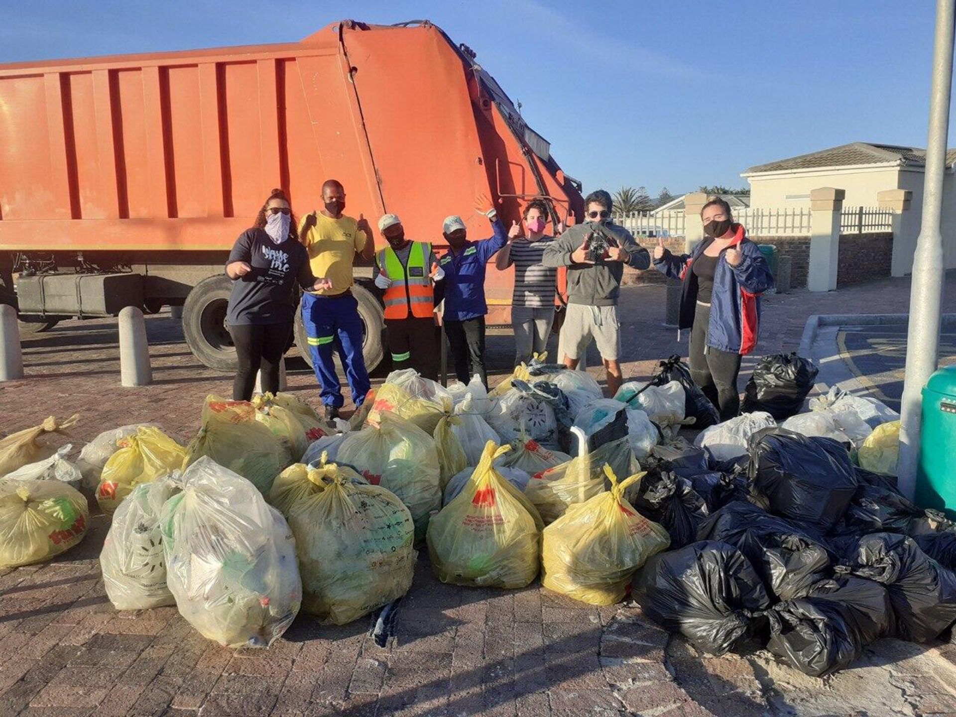 Zoe Prinsloo, the founder and CEO of Save a Fishie, and other eco-activists behind garbage they collected during a beach clean-up in South Africa - Sputnik International, 1920, 30.03.2023